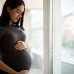 image-portrait-of-young-happy-pregnant-woman-standing-by-the-window